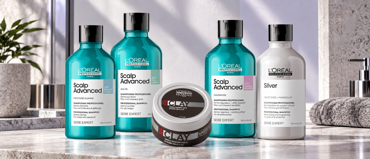 L’Oréal Professionnel Scalp Advanced shampoos, Silver shampoo and Homme styling clay on pale stone.