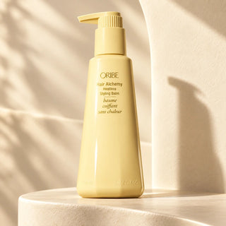 Oribe Hair Alchemy Heatless Styling Balm on a sunlit champagne ledge