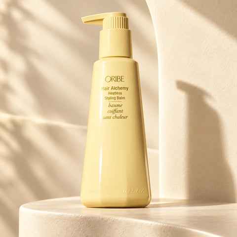 Oribe Hair Alchemy Heatless Styling Balm on a sunlit champagne ledge
