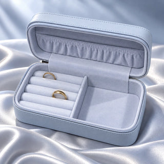 Open pale blue Kerasilk jewellery box with velvet compartments, displayed on silver blue silk.